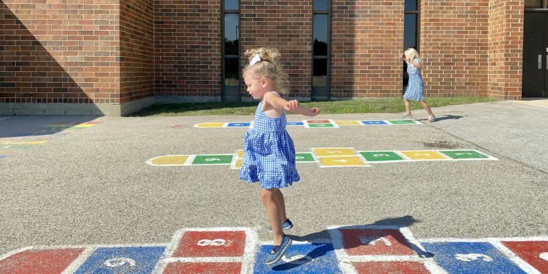 Little girls playing hopscotch on the school playground